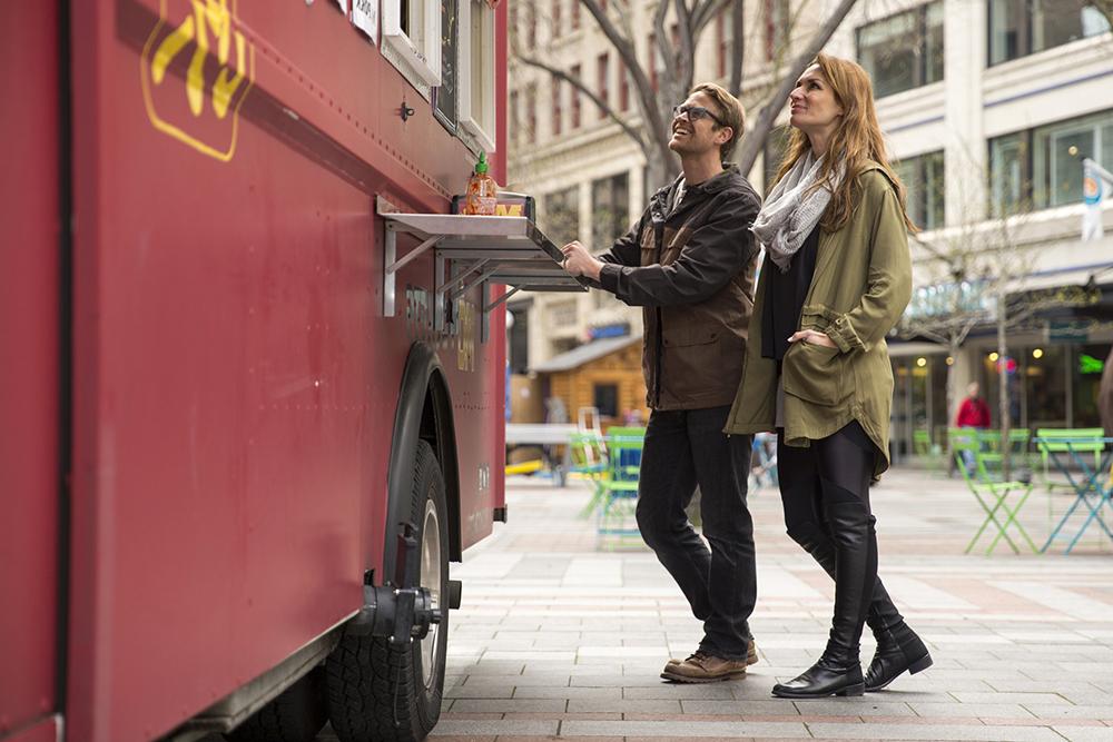 A couple ordering food from a street vendor.